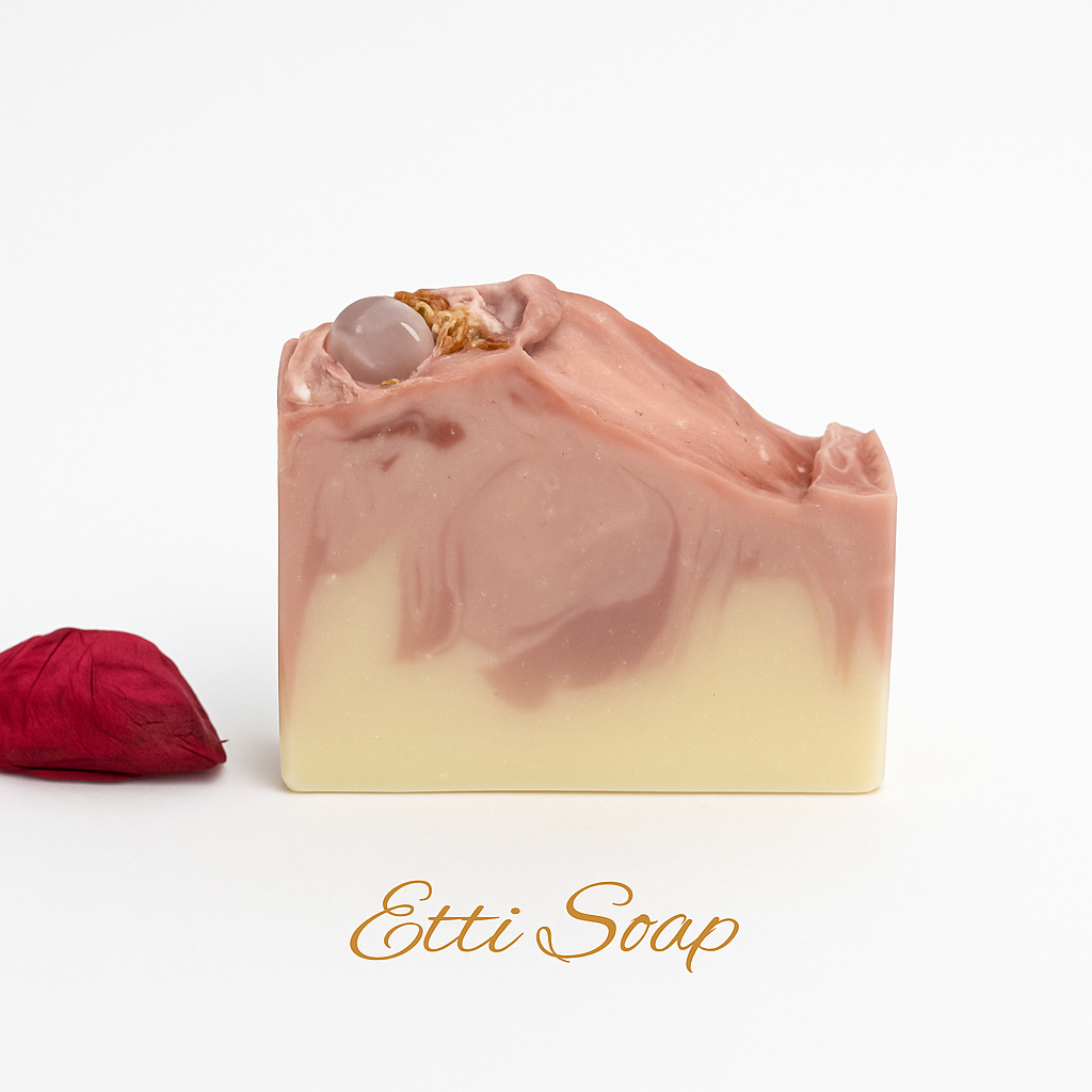 Artisan handmade rose soap with polished rose quartz crystal and floral details – photographed in soft white lighting.