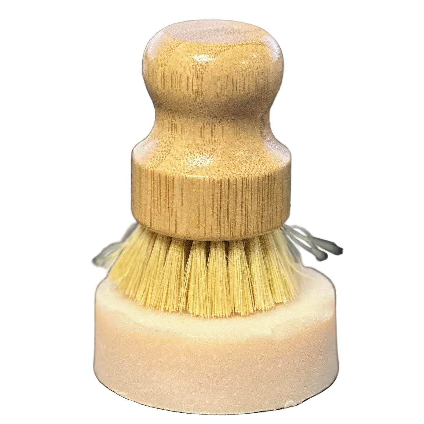 Small brush with wooden handle and bristles on a wooden surface, keyboard in the background