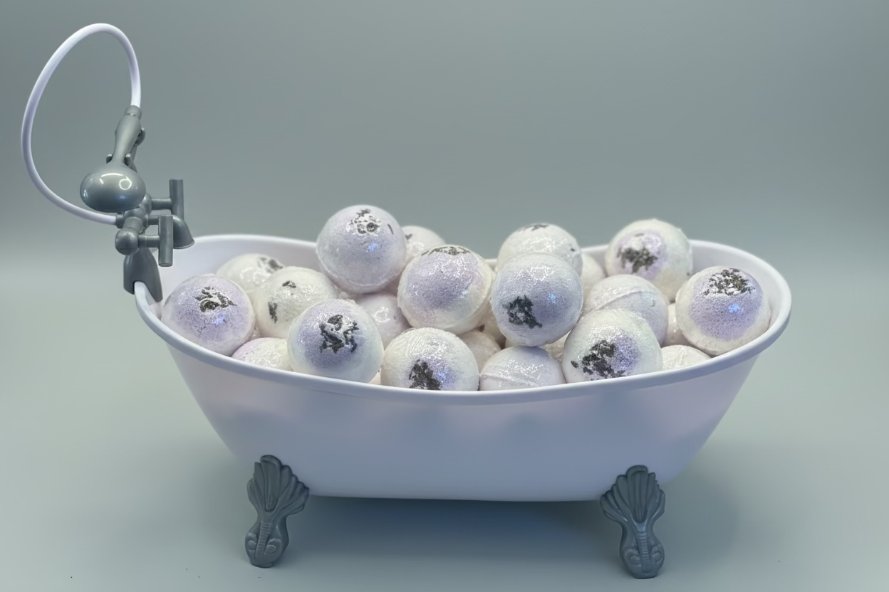 Decorative bathtub filled with snowball-like ornaments on a wooden surface.