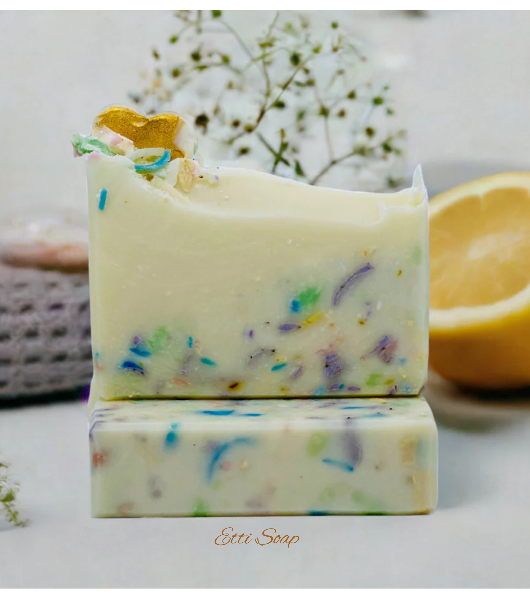Etti Soap artisan soap with rainbow specks and golden heart decoration, photographed under soft white lighting on a white backdrop.